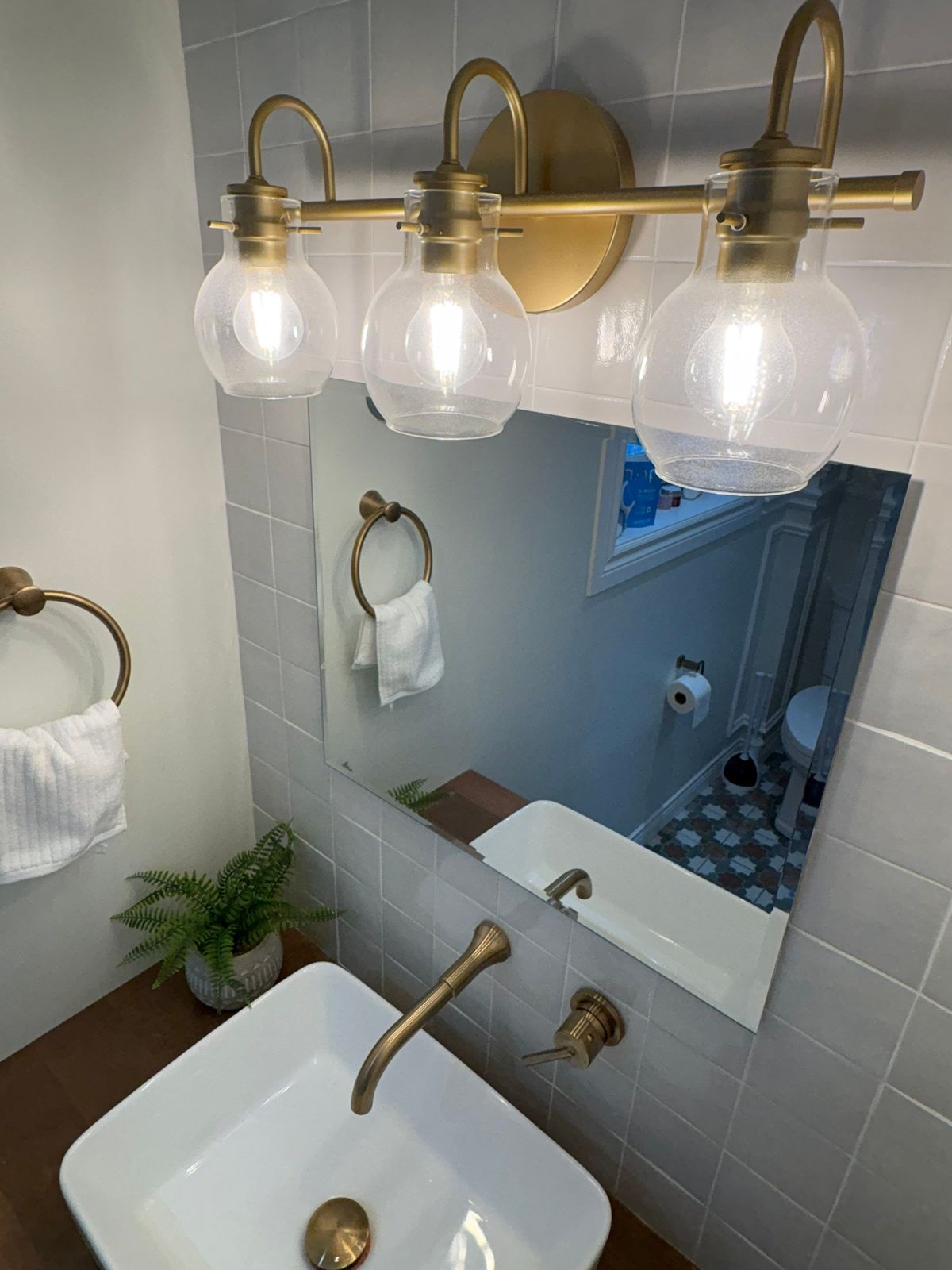 New Cove vanity mirror and brass sconce lighting.
