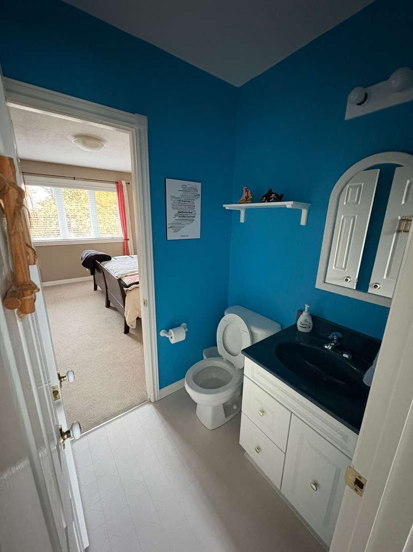 The Kensington powder room before renovation — dark blue walls and a builder-grade vanity.