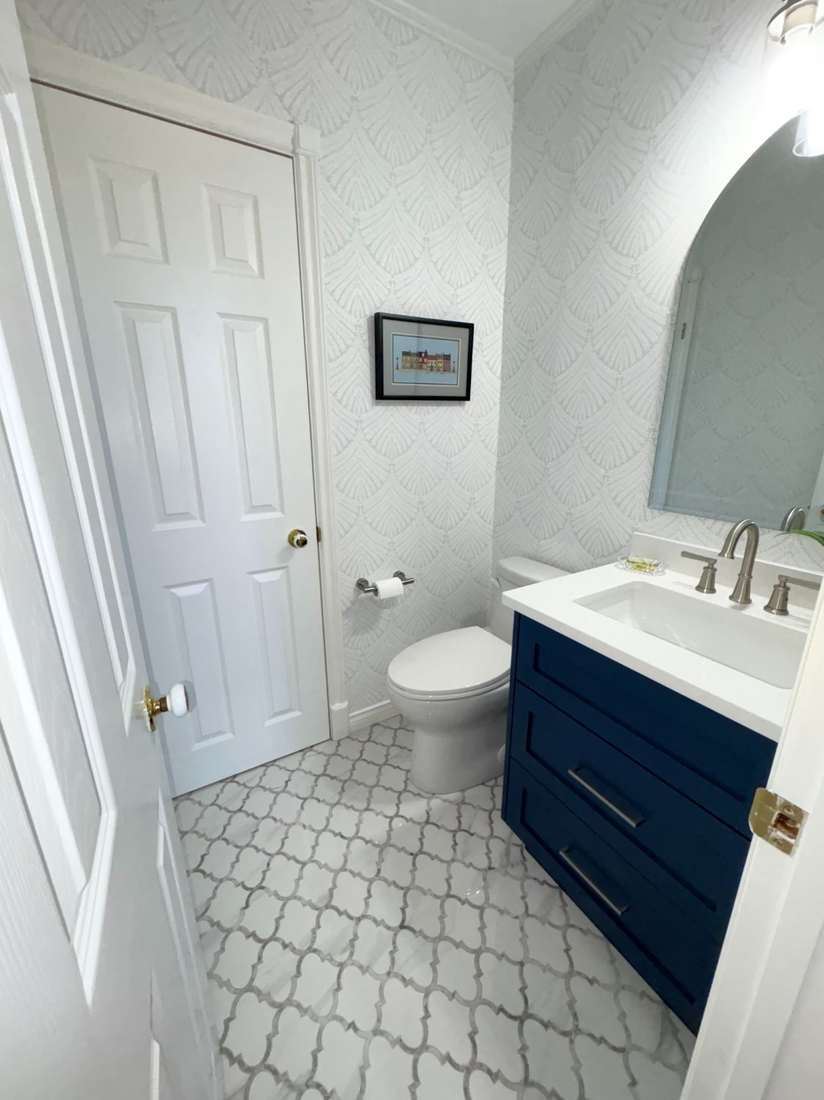 Kensington powder room — arched mirror and framed artwork.